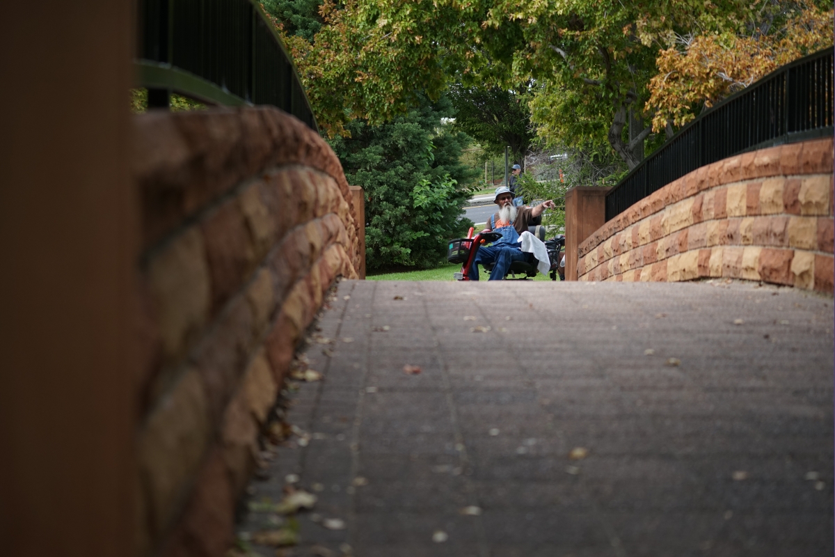 Man points on the far side of a bridge